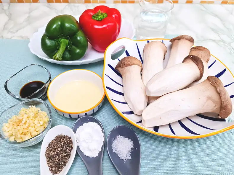 ingredients All the ingredients needed: king trumpet mushrooms, capsicums, tapioca flour, water, cooking oil, minced garlic, salt, light soy sauce, and coarse black pepper.