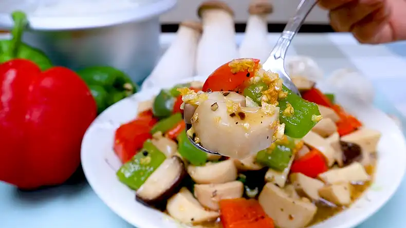 lets eat A spoon holding up chunks of Eryngii mushrooms, capsicum in luscious black pepper gravy.