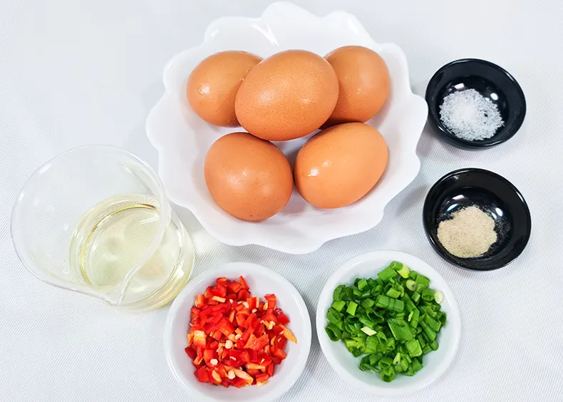 ingredients All the ingredients needed: eggs, salt, pepper, cooking oil, chopped spring onions and red chilli.