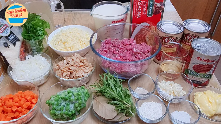 ingredients All the ingredients needed: chicken stock, parsley, cheese, milk, lasagna, tomato paste, butter, minced garlic, salt, tapioca flour, pepper, minced lamb, rosemary, bay leaves, button mushrooms, green peas, yellow onions, carrot and parmesan cheese.