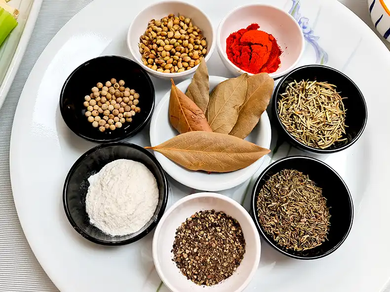 dried spices All the dried spices used: white peppercorns, coriander seeds, coarse black pepper, dried thyme, dried rosemary, chilli powder, garlic powder, and bay leaves.