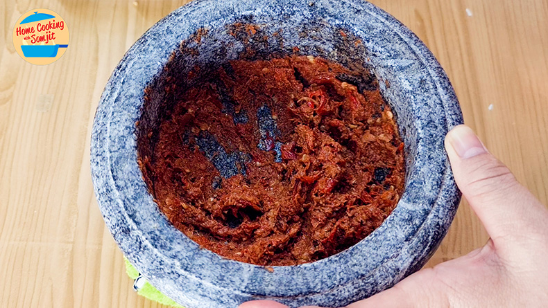 pounding sambal belacan Toasted chilli and shrimp paste in a mortar.