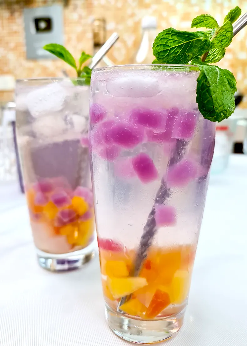 both drinks The mocktail in the foreground, and cocktail in the background