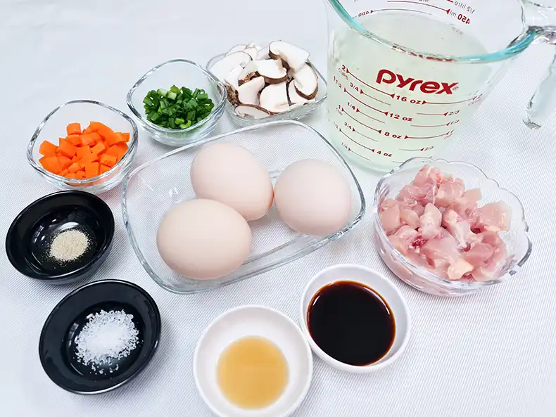 ingredients All the ingredients needed: chicken stock, eggs, chicken meat, shiitake mushrooms, spring onions, carrots, salt, pepper, sesame oil and light soy sauce.