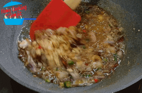 stirring sauce Stirring the chillis, shallots and dried shrimp in the sweet shrimp paste sauce.
